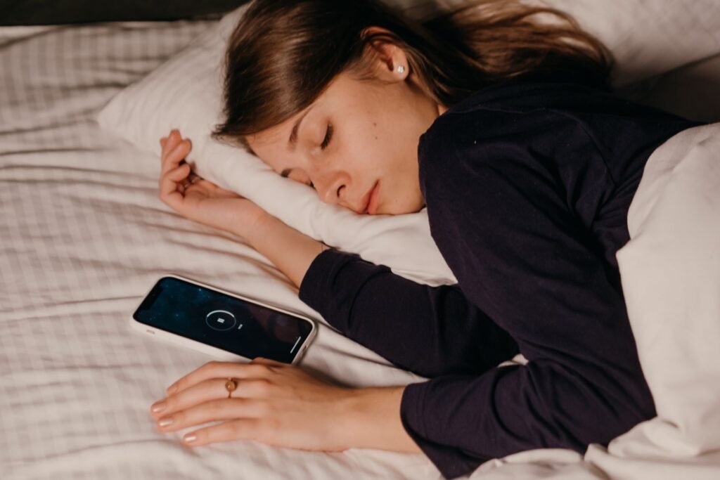 someone sleeping with a phone on the bed